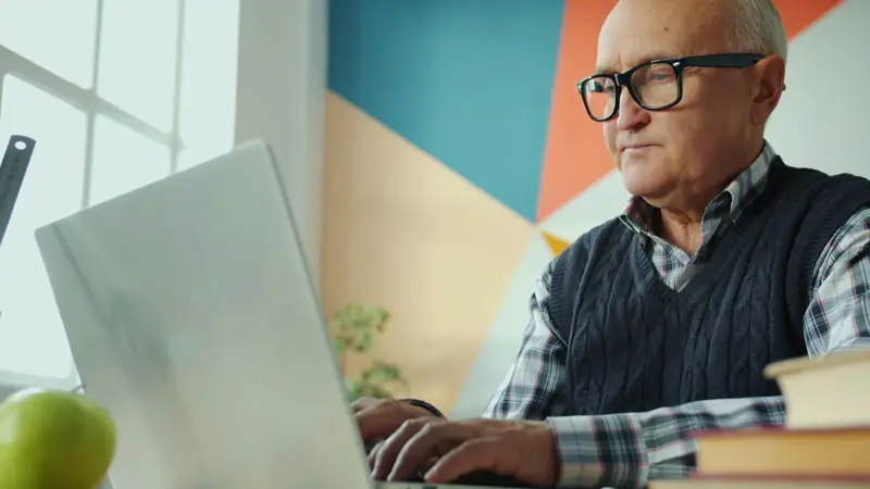 An older man learning to use a laptop