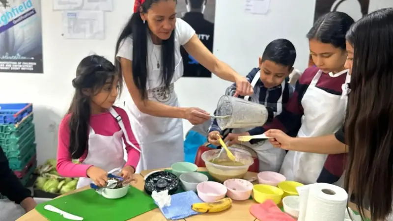 Children and adults cooking a vegetarian meal together